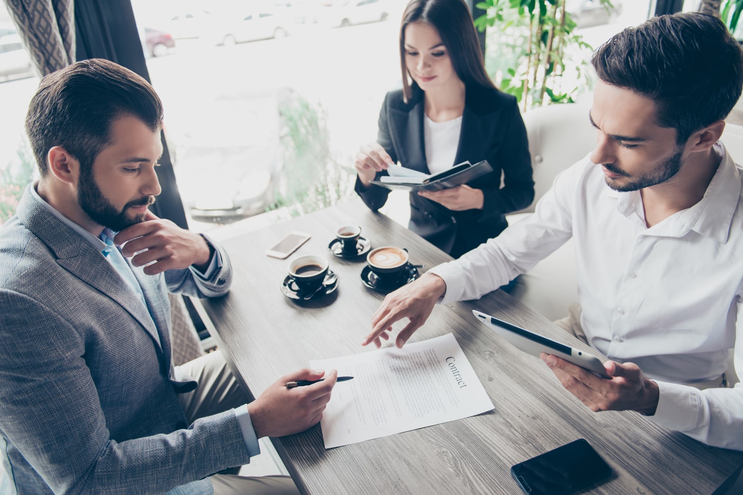 Trois personnes relisant un contrat