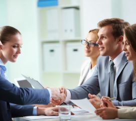 Groupe de personnes en train de se serrer la main autour d'une table